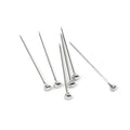 Six stainless steel cocktail picks with spherical handles arranged in a group.