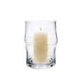 Clear glass hurricane with twisted sides holding a lit cream-colored pillar candle.