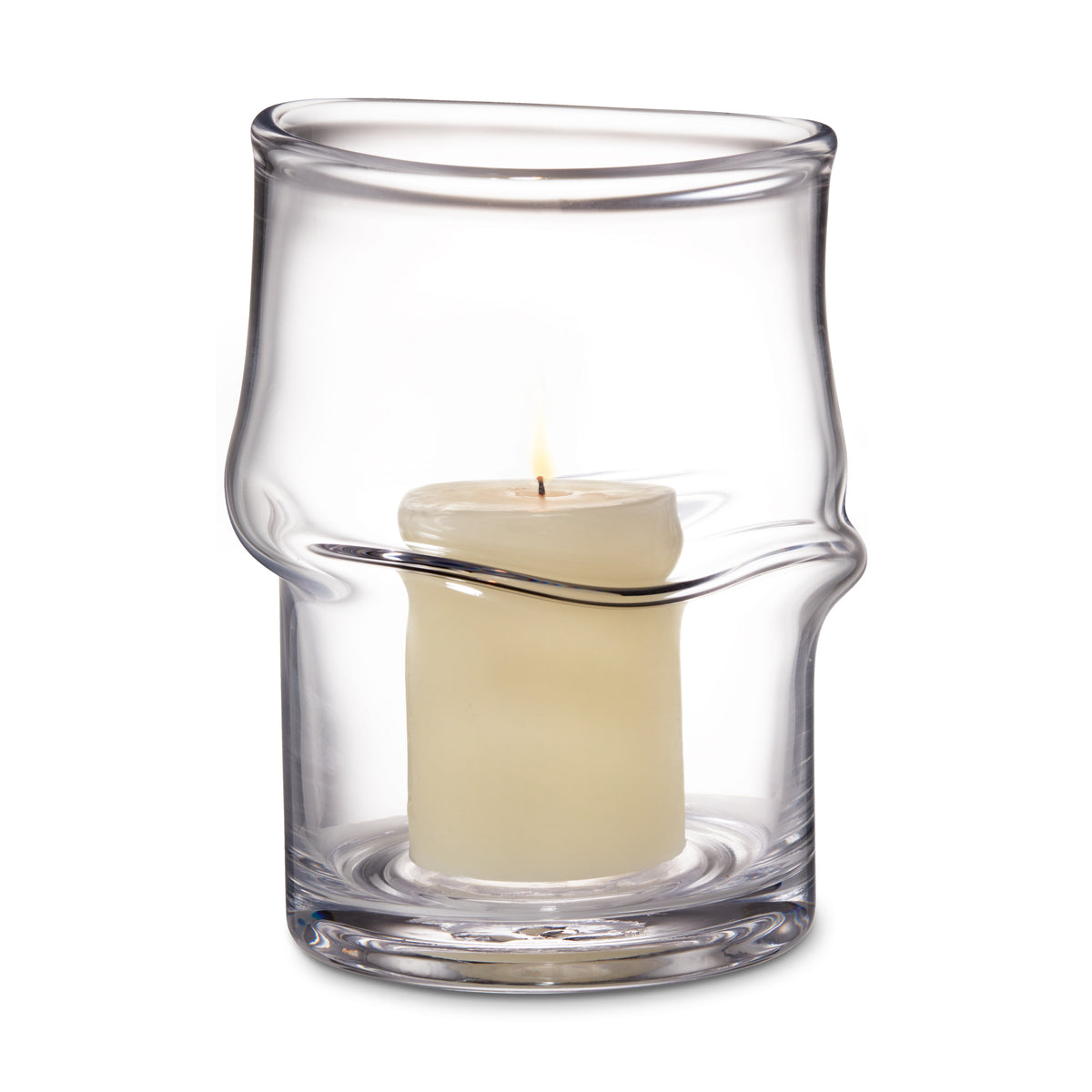 Clear glass hurricane with twisted design holding a lit cream-colored pillar candle.