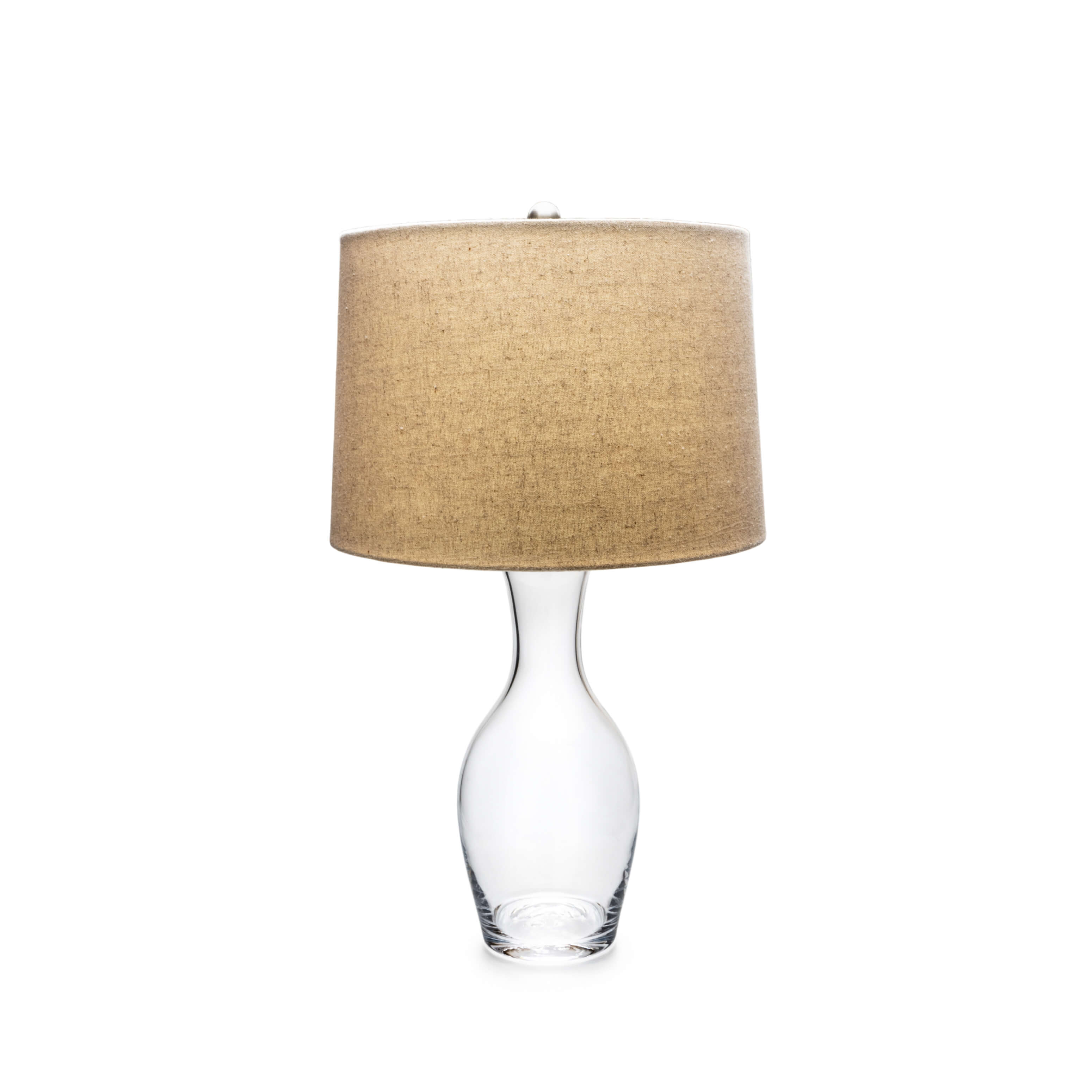 Clear glass bottle-shaped base with tan linen cylindrical shade and metal top finial.