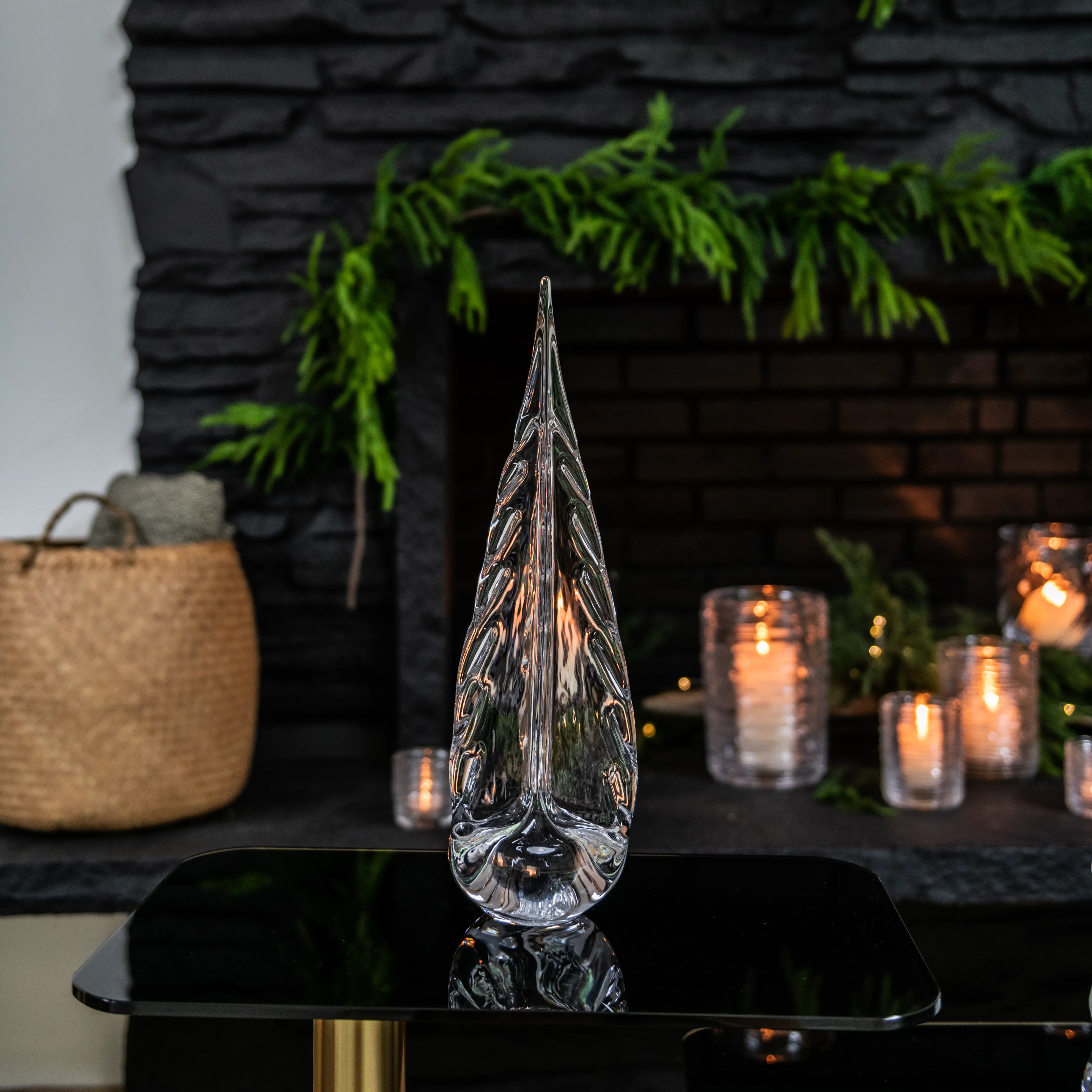 Clear glass teardrop-shaped tree sculpture with textured surface detail on black base.