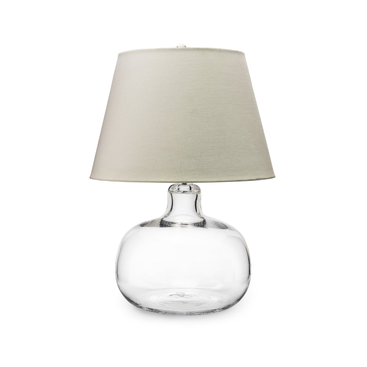 Clear glass round base lamp with cream linen tapered shade.