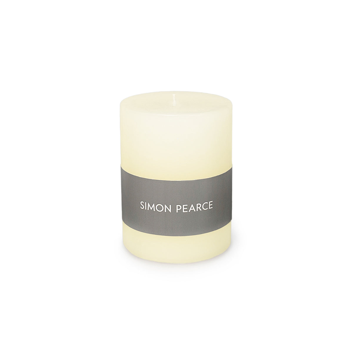 Ivory pillar candle with gray band label reading "SIMON PEARCE" and visible wick at top.