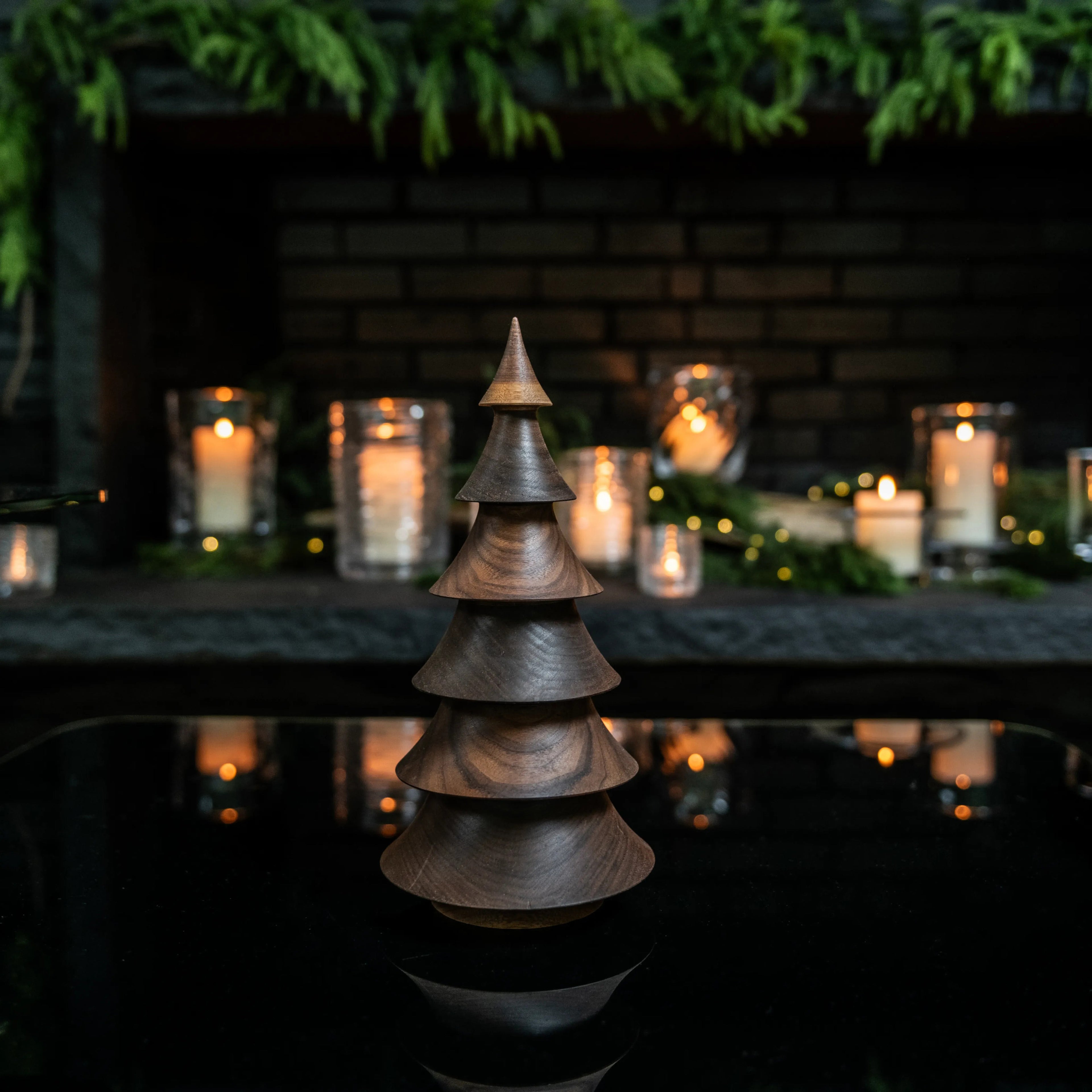 Wooden evergreen tree decoration in dark walnut with stacked tiered rings and pointed top.