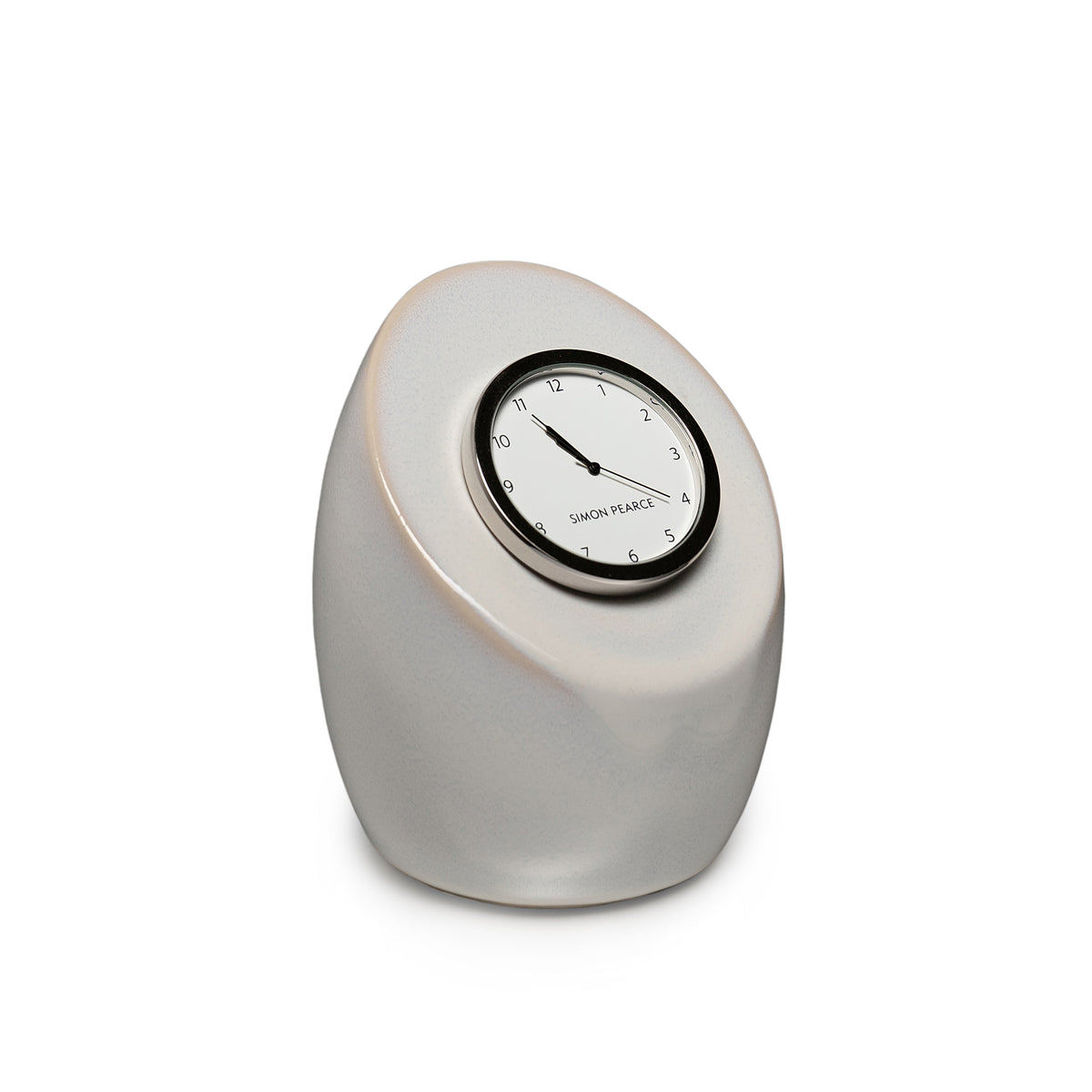 Cream-colored pottery clock with black-rimmed face and Simon Pearce branding, egg-shaped form.