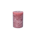Pink pillar candle with white wick and textured surface.