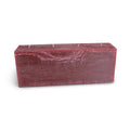 Berry-colored rectangular candle with four white wicks on top and textured wax surface.