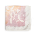 Apricot linen napkin with white botanical leaf print fading from peachy-orange to mauve tones.