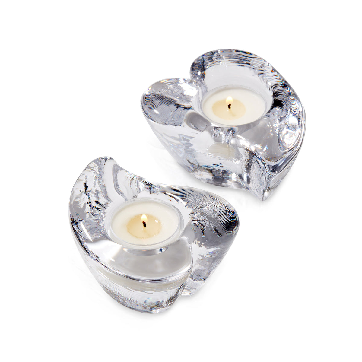 Two clear glass heart-shaped tealight holders with cream-colored candles and twisted metal detailing.