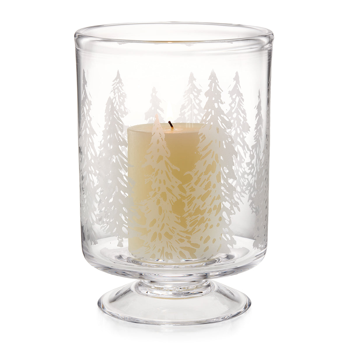 Clear glass hurricane with engraved forest tree design surrounding a cream-colored candle with black wick.