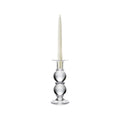 Clear glass candlestick with stacked spherical base holding a cream-colored taper candle.
