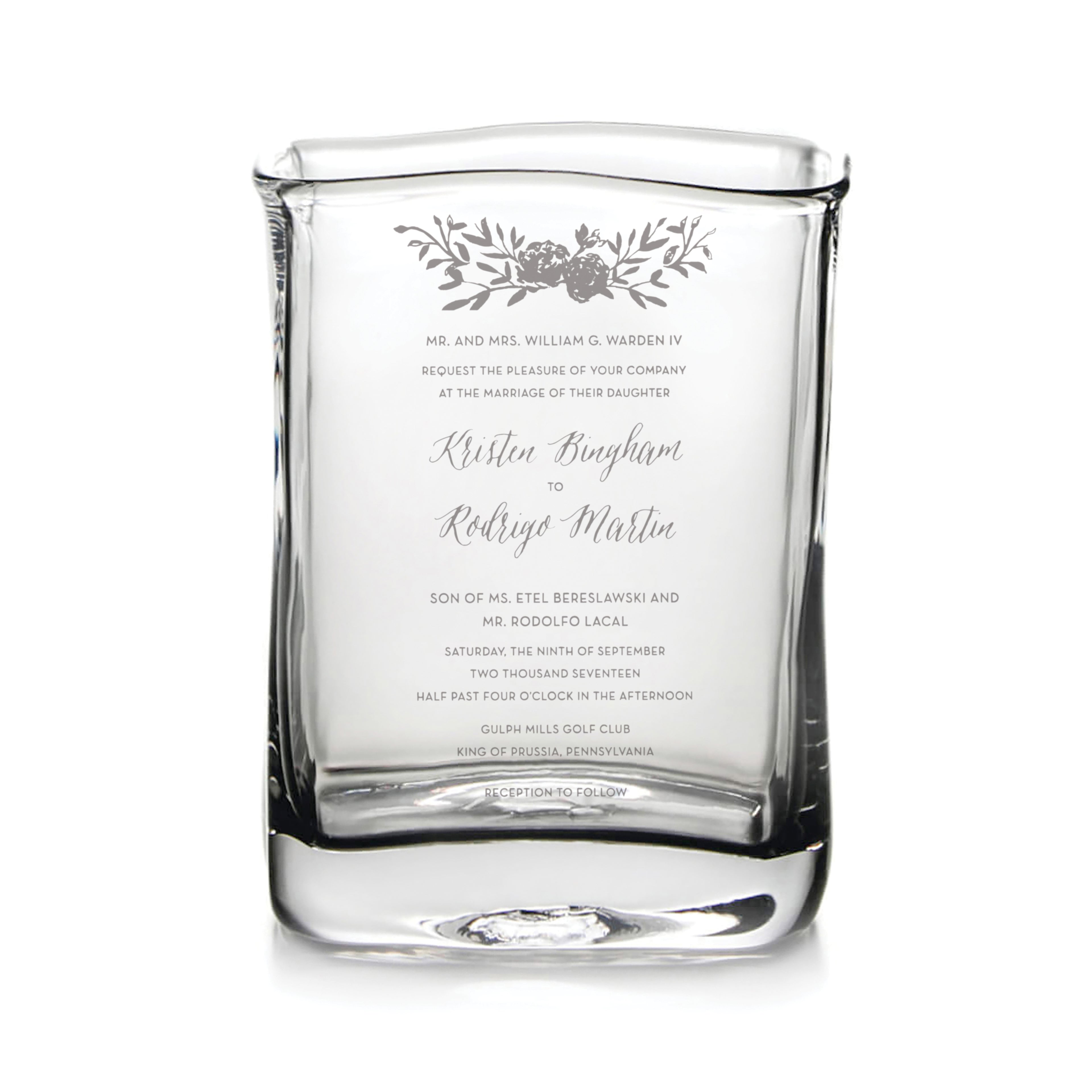 Clear glass vase engraved with wedding invitation text and floral design.