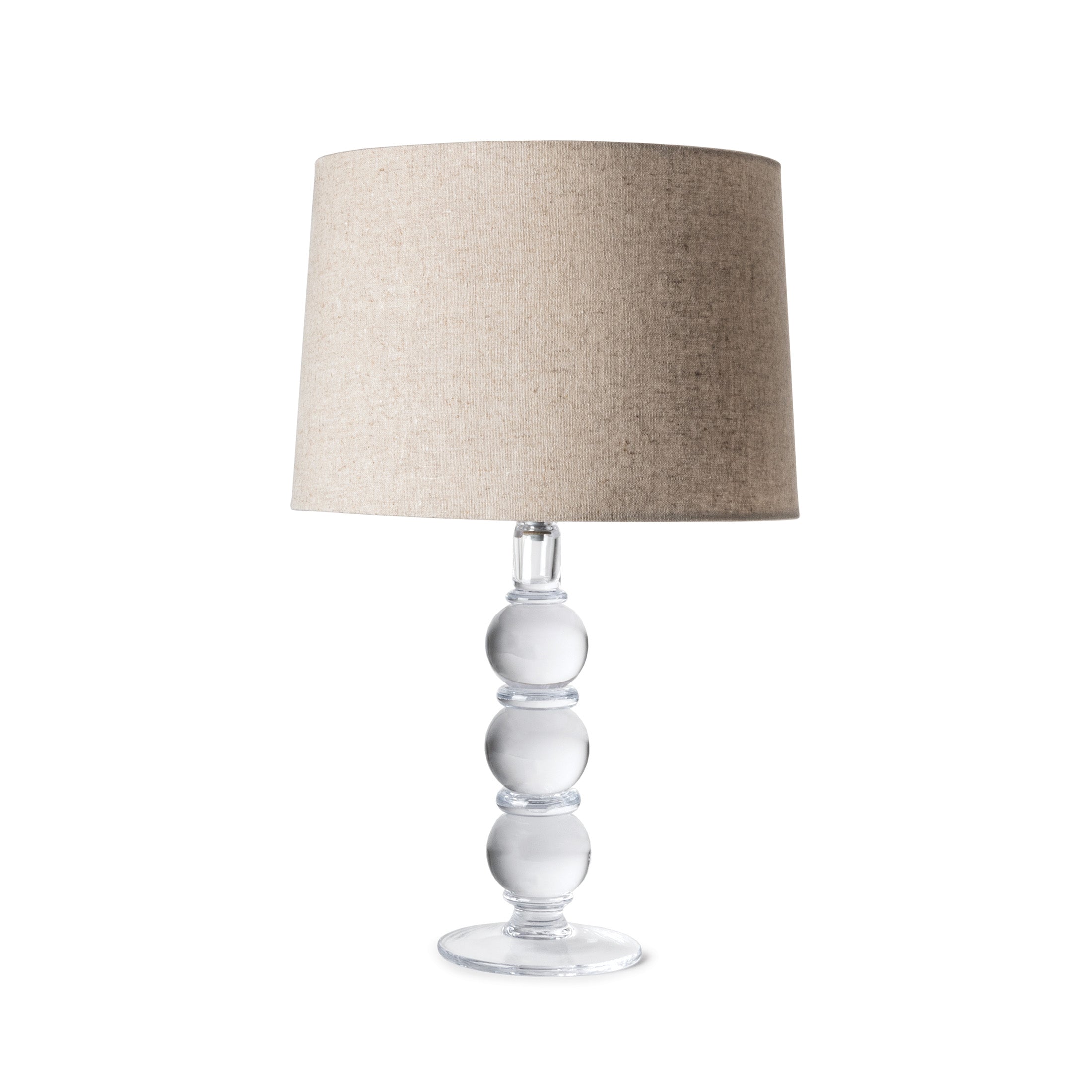 Table lamp with stacked clear glass spheres base and beige linen drum shade.