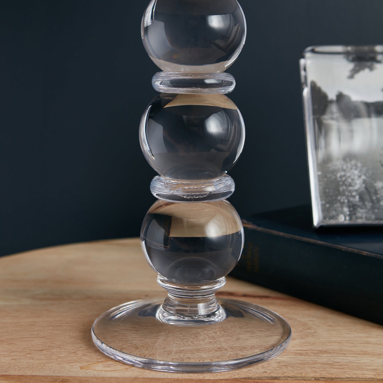 Stacked glass spheres with wooden bands on a circular wooden base with cord.