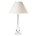 Tall table lamp with clear glass teardrop-shaped base and cream-colored cone shade.
