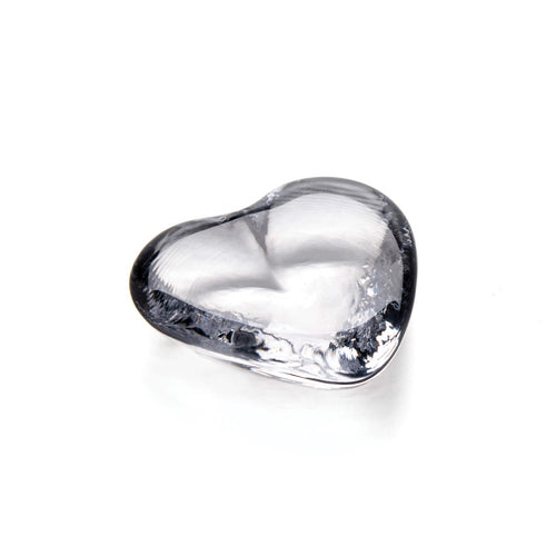 Clear glass heart-shaped object with smooth, rounded surfaces and light reflections.