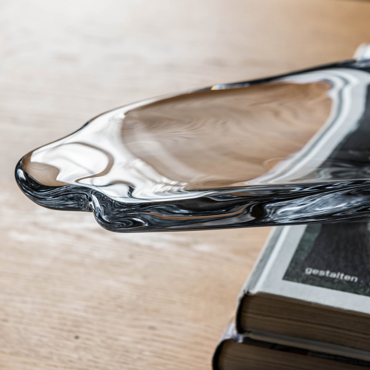 Large sculptural centerpiece with organic curved form in black and white swirled glass, displayed on wooden surface.