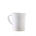 White ceramic mug with horizontal stripe details and a curved handle.