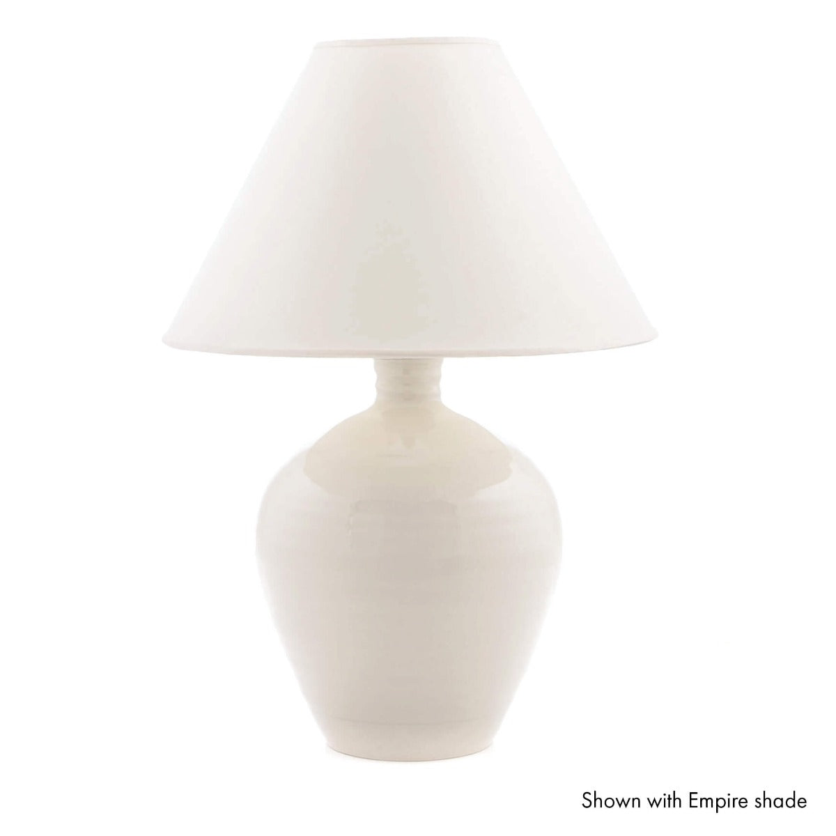 Cream ceramic table lamp with rounded base and white fabric empire shade.