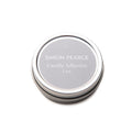 Small metal tin with gray label reading "SIMON PEARCE Candle Adhesive 1 oz."