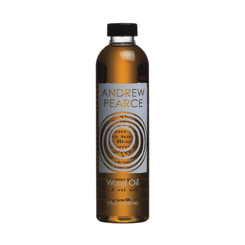 Amber glass bottle of Andrew Pearce Wood Oil with black cap and concentric circle label design, 8 fl oz size.