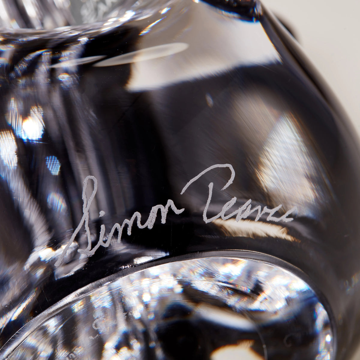 Black crystal five-sided evergreen sculpture with handwritten signature and plaid ribbon bow detail.