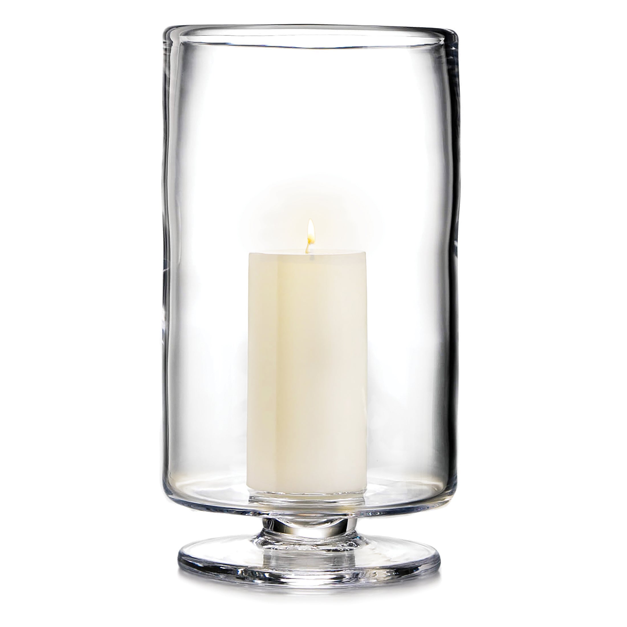 Clear glass hurricane vase with pedestal base holding a lit cream pillar candle.
