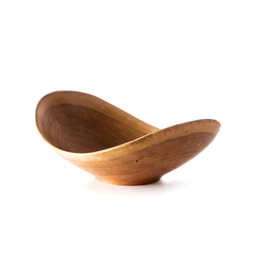 Cherry wood bowl with asymmetrical rounded form and natural live edge rim.