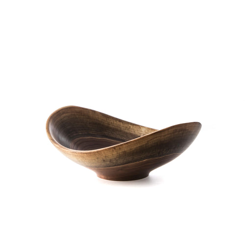 Black walnut wooden bowl with asymmetrical live edge and curved, organic form.
