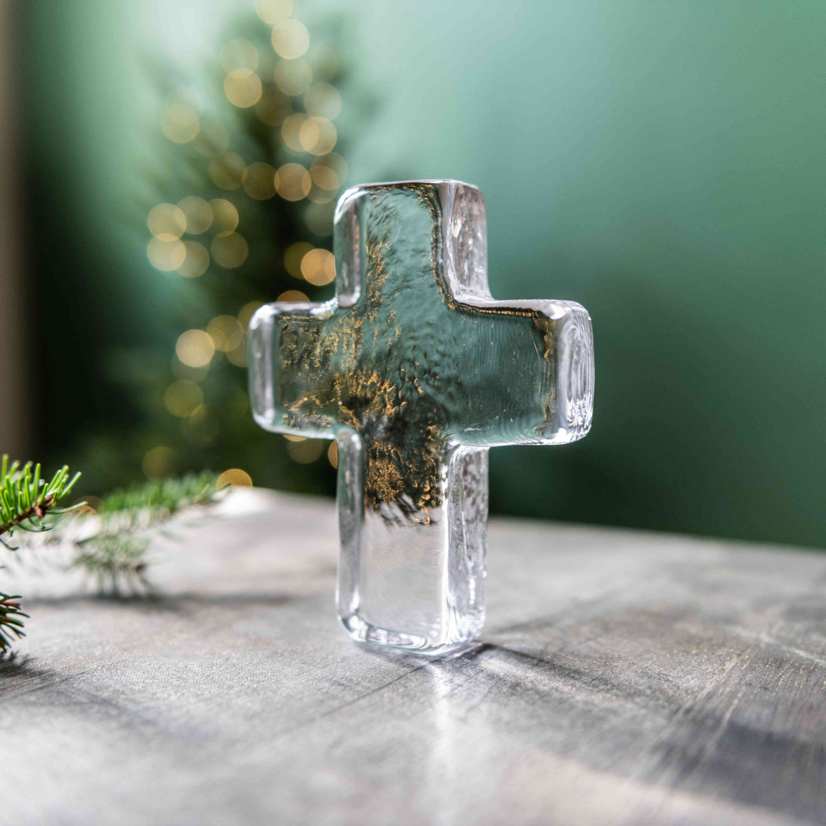 Clear glass cross with gold leaf accents and teal-blue resin interior.