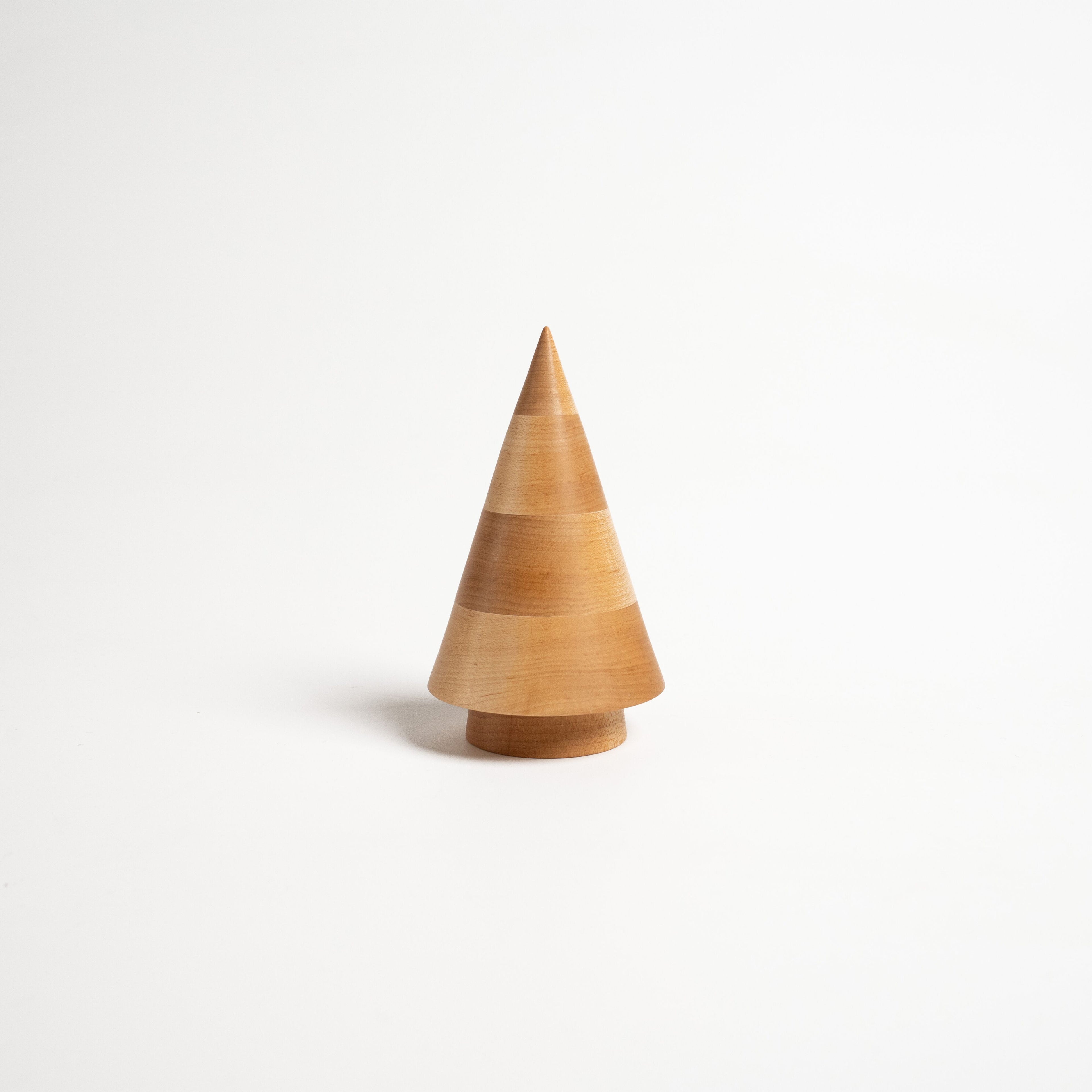 Wooden cone-shaped evergreen figurine in natural maple wood with a cylindrical base on white background.