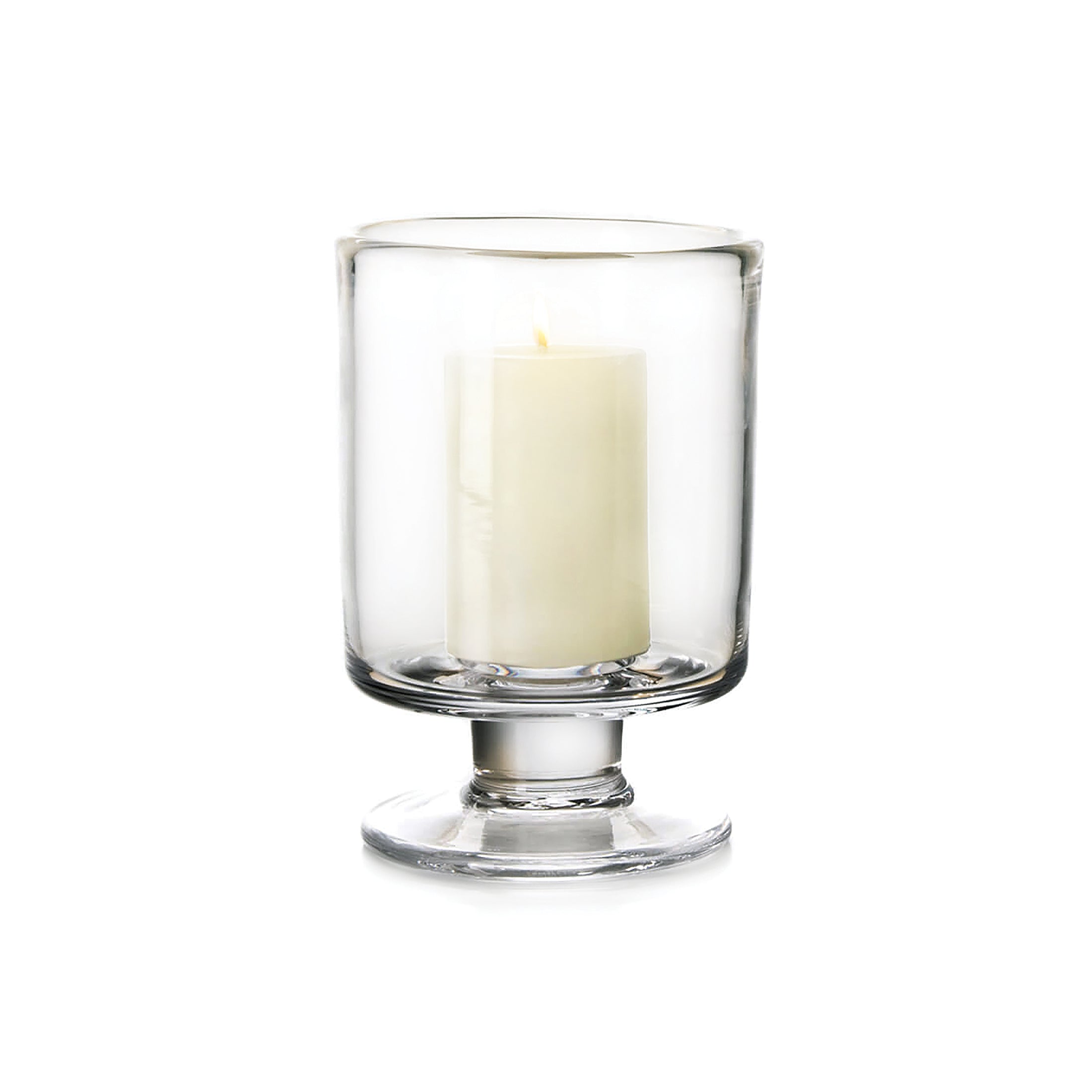 Clear glass hurricane vase with pedestal base containing a cream-colored pillar candle.