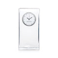 Clear tall rectangular clock with circular dial showing Simon Pearce branding and black hands.