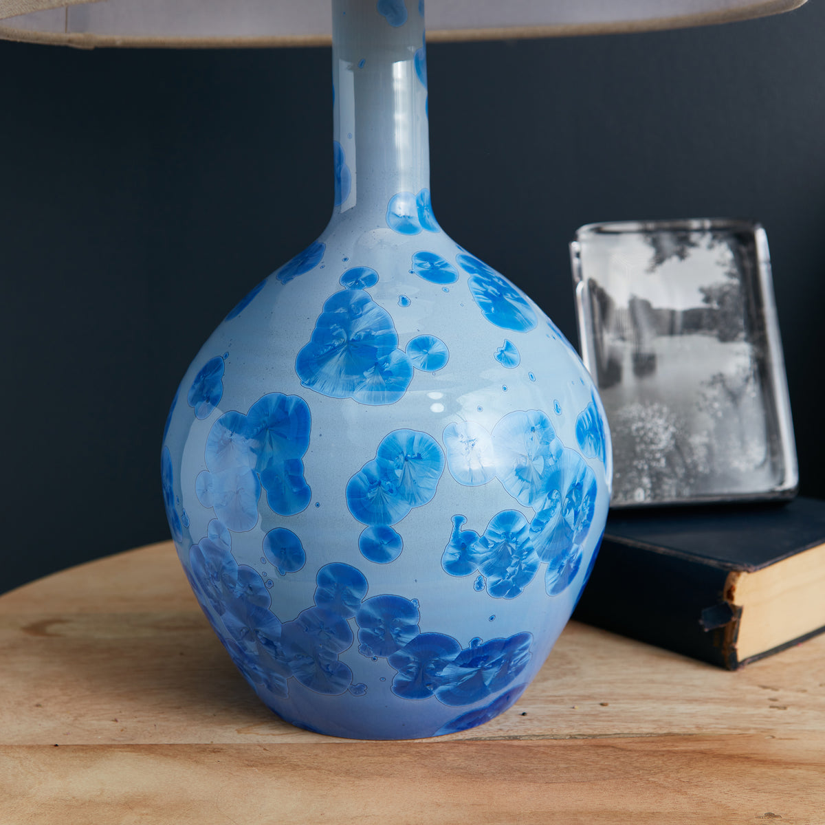 Blue and white porcelain table lamp with floral motifs and a round bulbous base with a cylindrical neck.