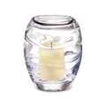 Clear glass hurricane candle holder with cream-colored pillar candle inside and ribbed detailing on exterior.