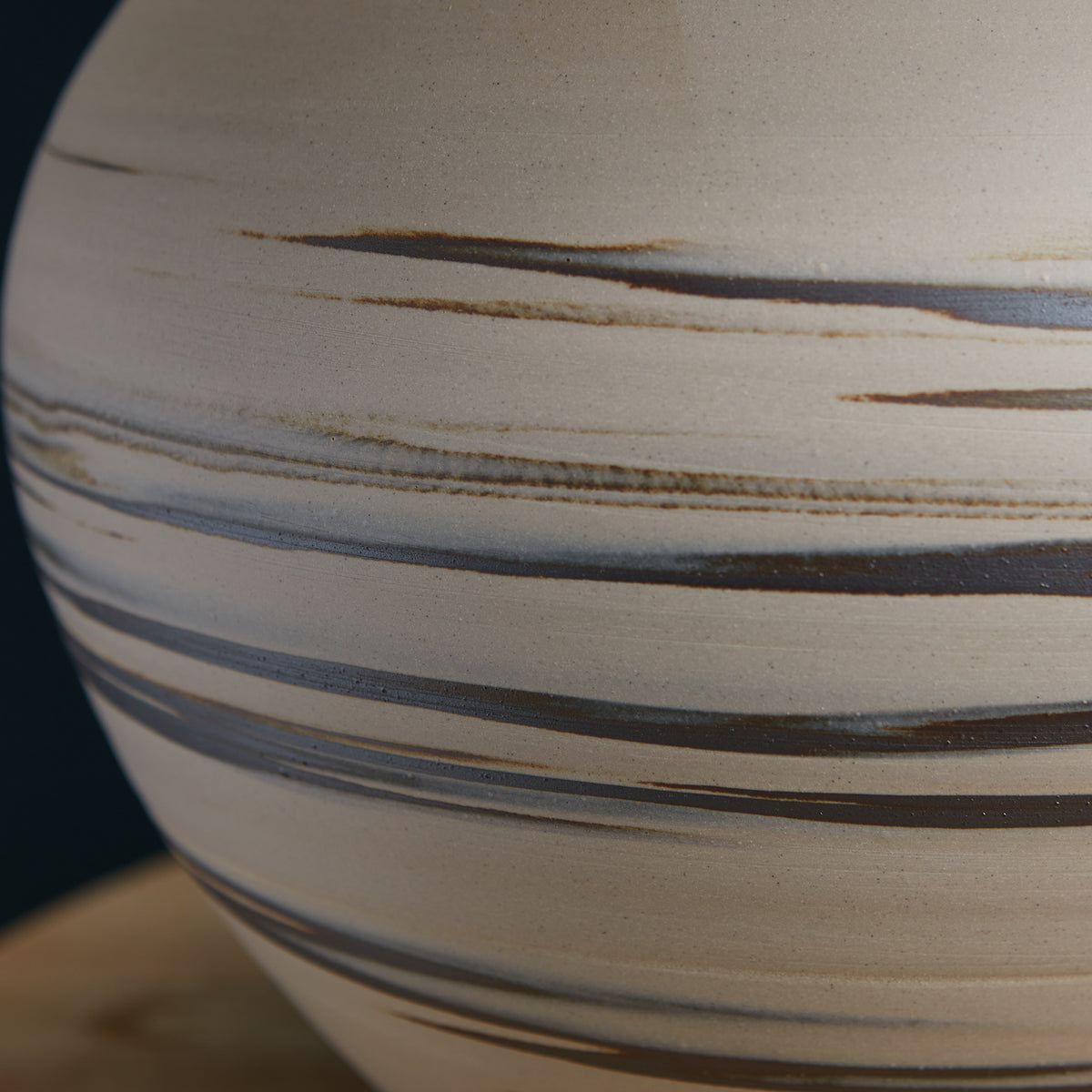 Round ceramic lamp base with cream and tan body featuring horizontal brown and gray stripe detailing.