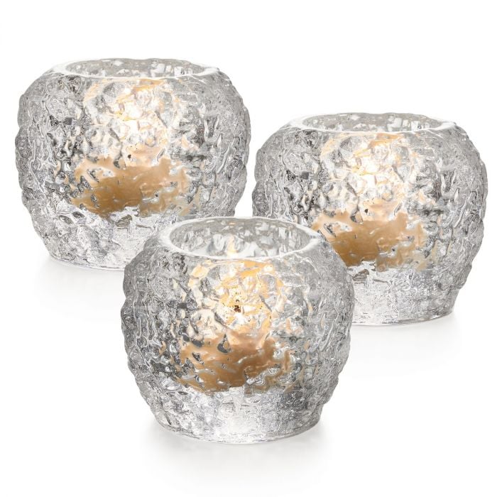 Three silver crackle tealight holders with tan candles inside.