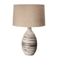 Tall table lamp with cream ceramic base featuring brown striped pattern and tan linen drum shade.