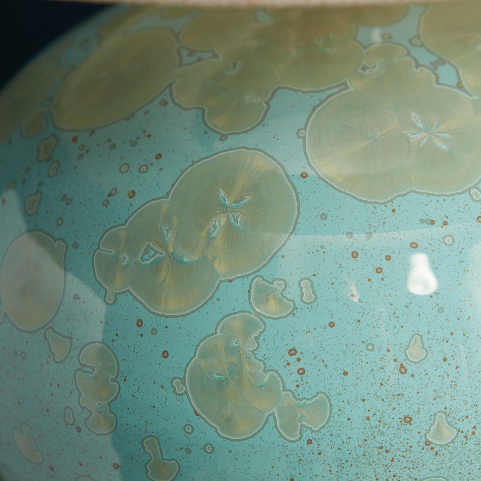 Turquoise crystalline jade lamp base with etched floral motifs and copper speckled detailing.