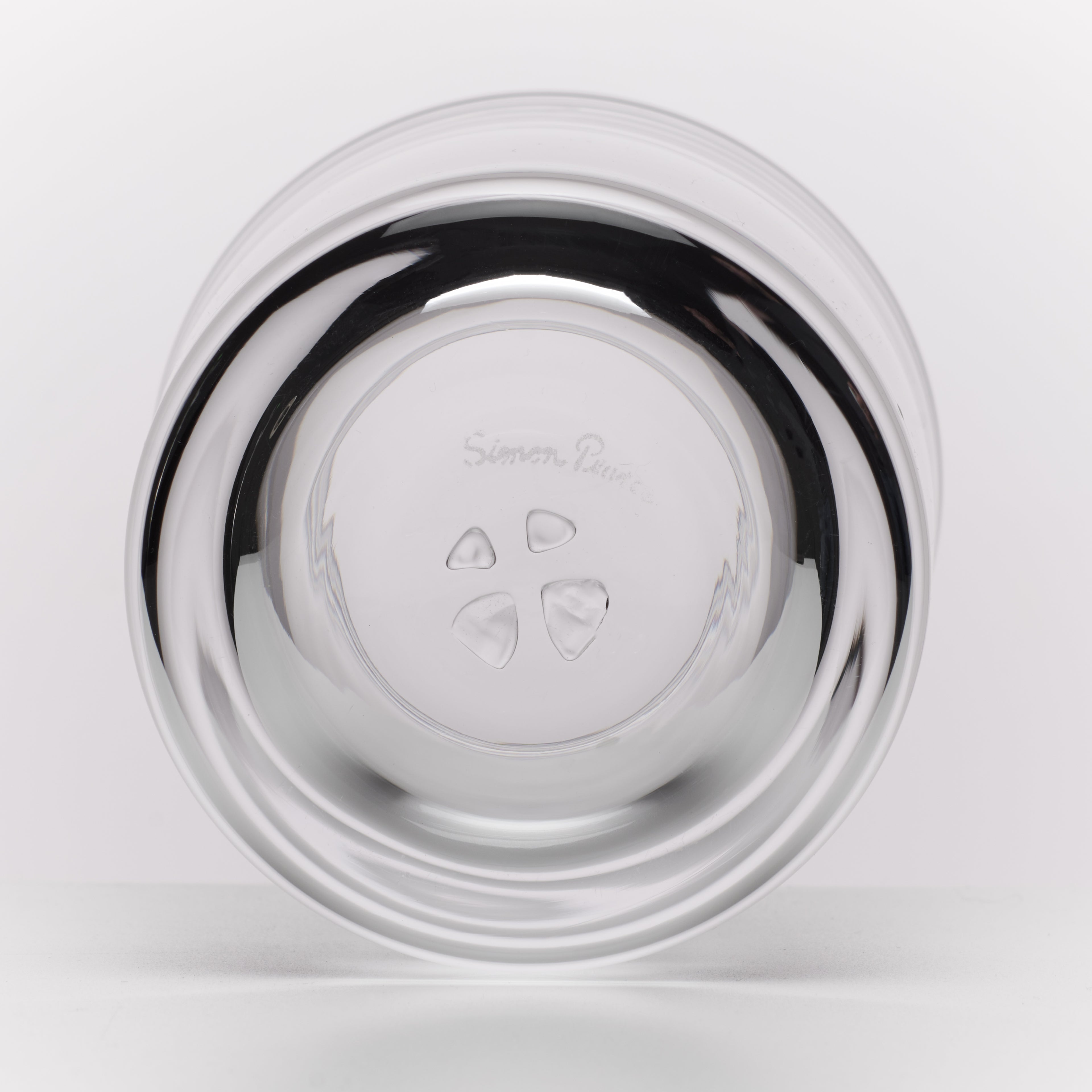 A round glass photographed from the bottom on a clean white background.