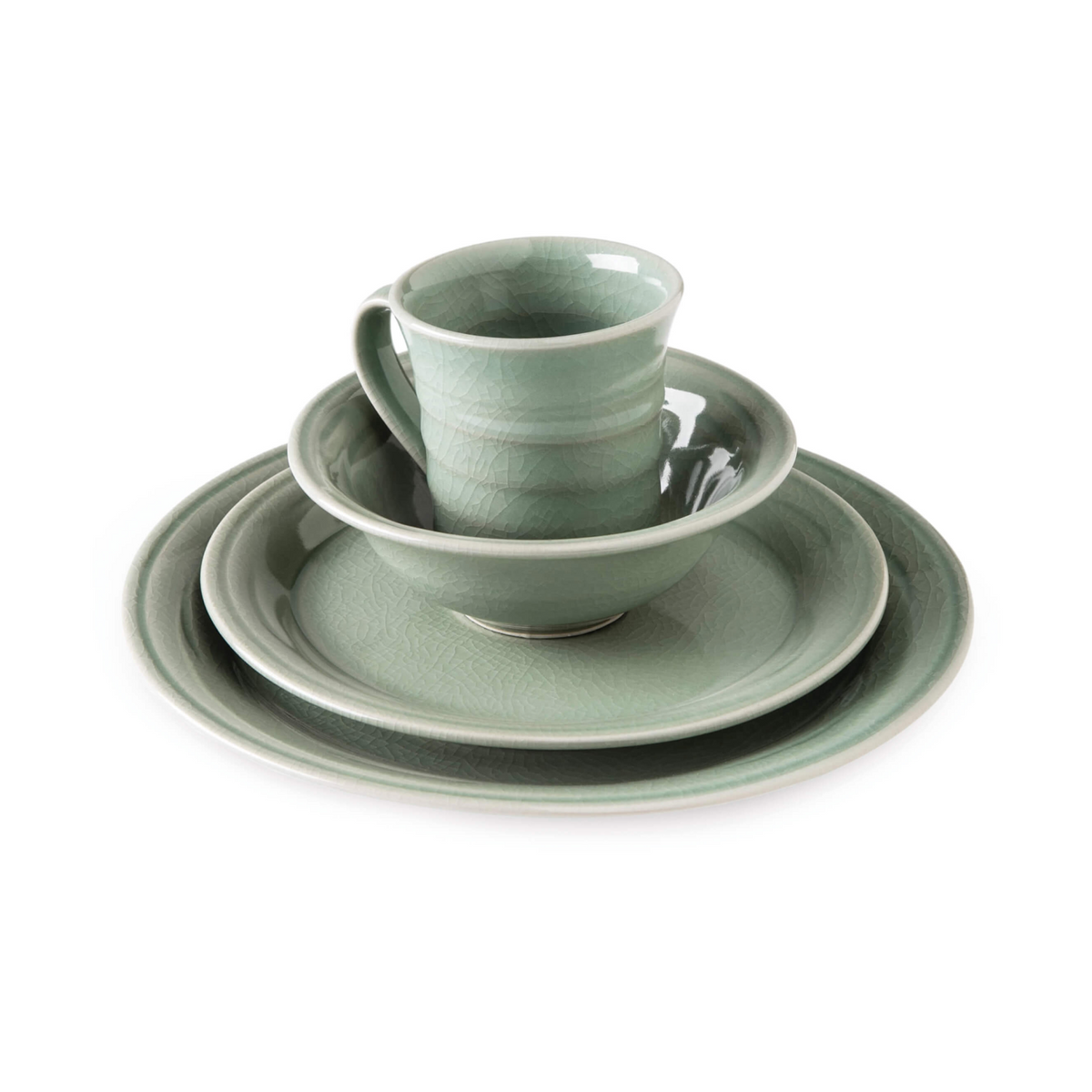 Celadon dinnerware set with crackle glaze includes stacked plates, bowl, and mug with handle.