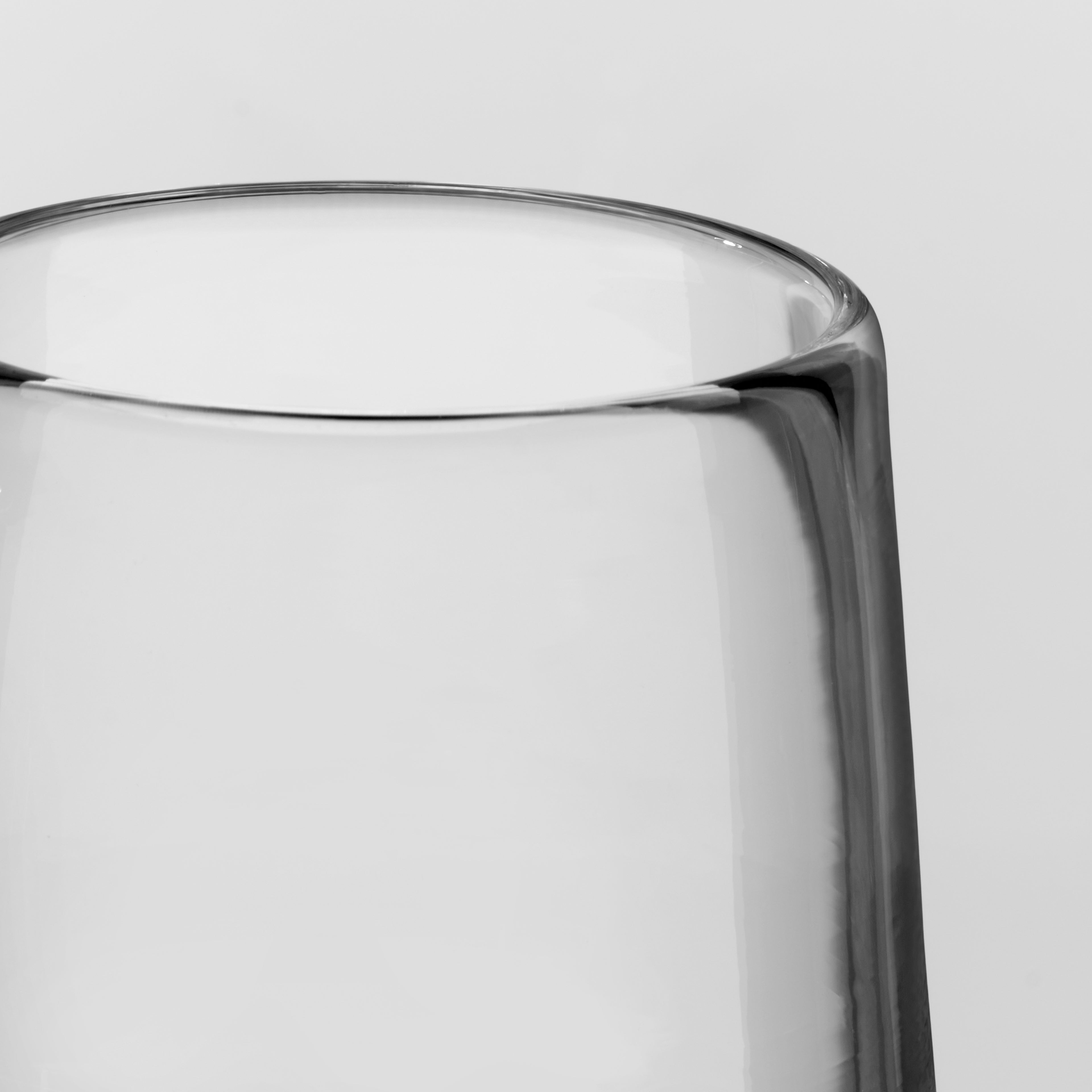 Close-up of a clear glass tumbler showing the rim and side profile against a light gray background.