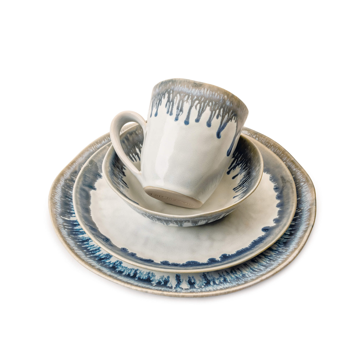 White ceramic teacup and saucer set with blue drip glaze pattern and textured rim detail.