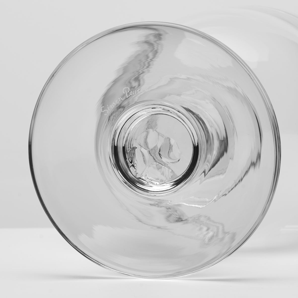 A clear glass bowl with a wide base and a textured pattern etched or molded inside, shown on a light gray background.