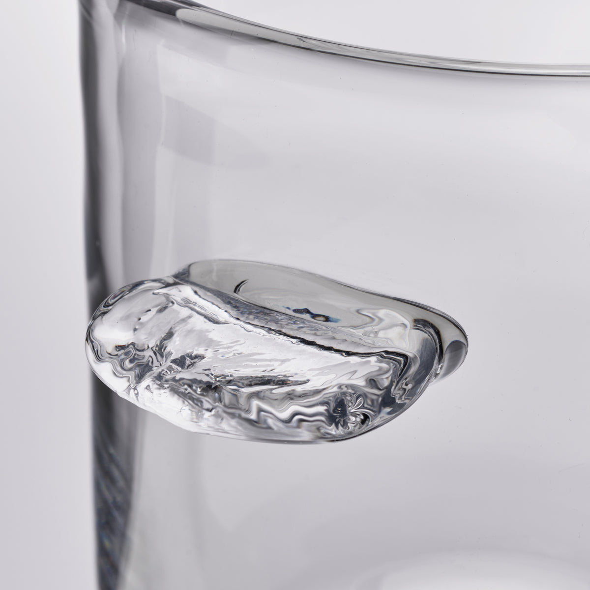 Clear glass ice bucket with organic curved rim and marbled interior pattern.