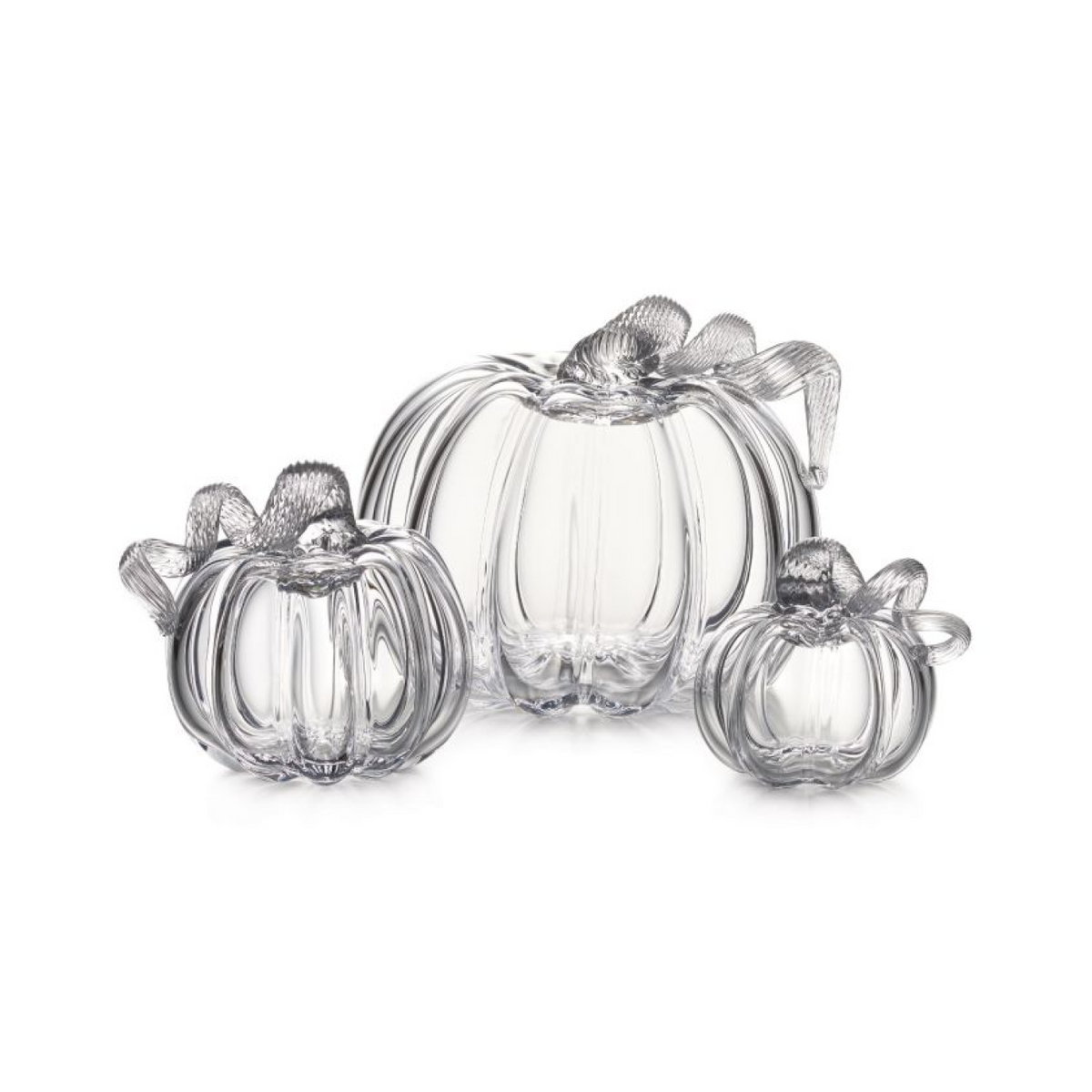 Three clear glass pumpkins in varying sizes with ribbed details and decorative leaf stems on top.