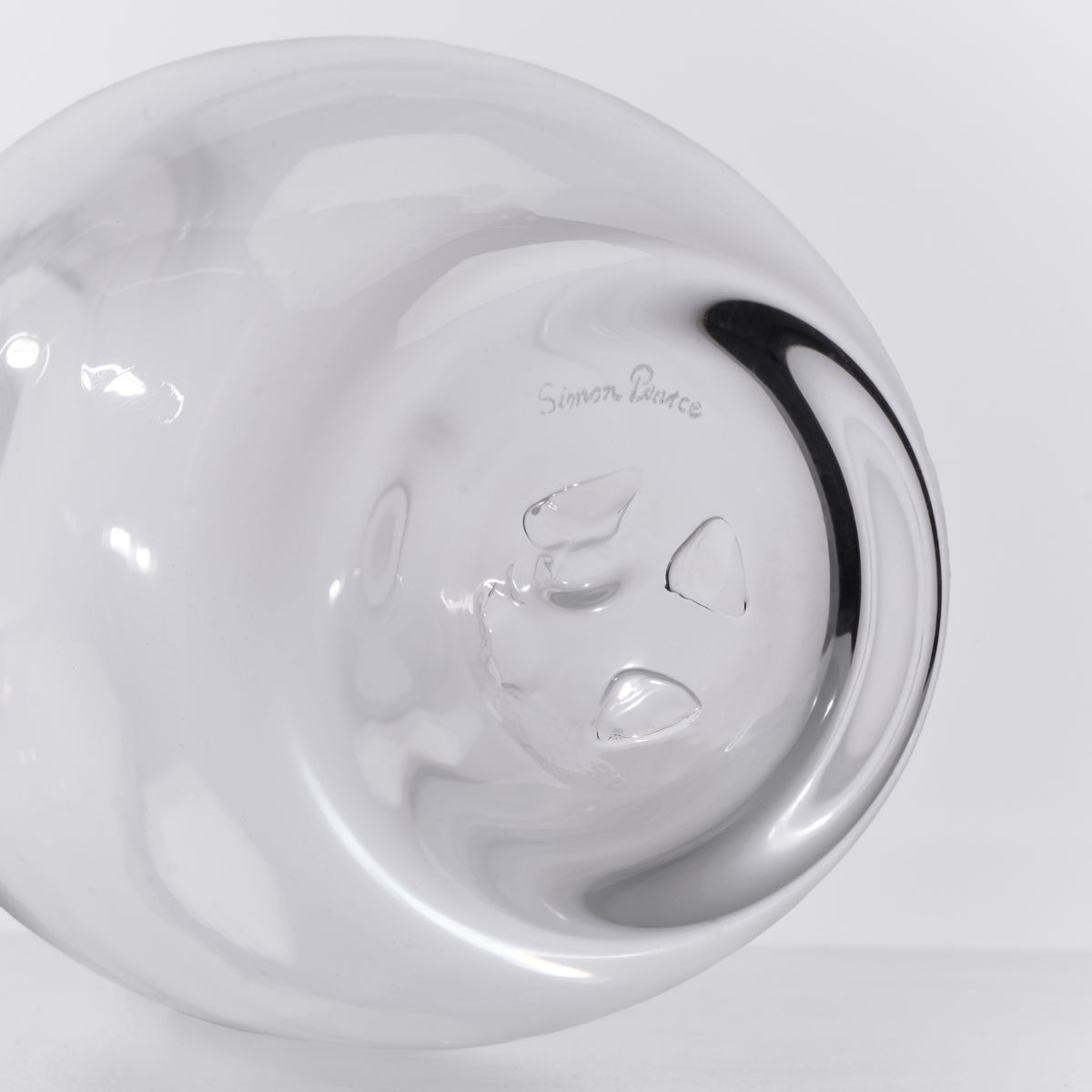 White ceramic carafe with black handle and leaf design etched on the body, shown from above.