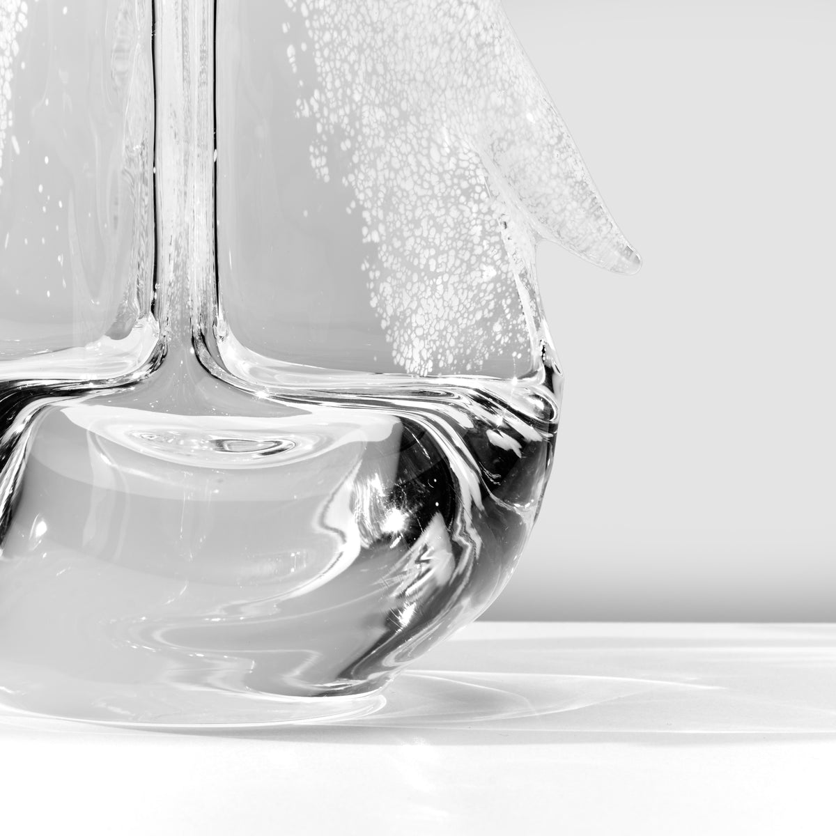 Clear glass vase with white frost-textured branch design against gray background.