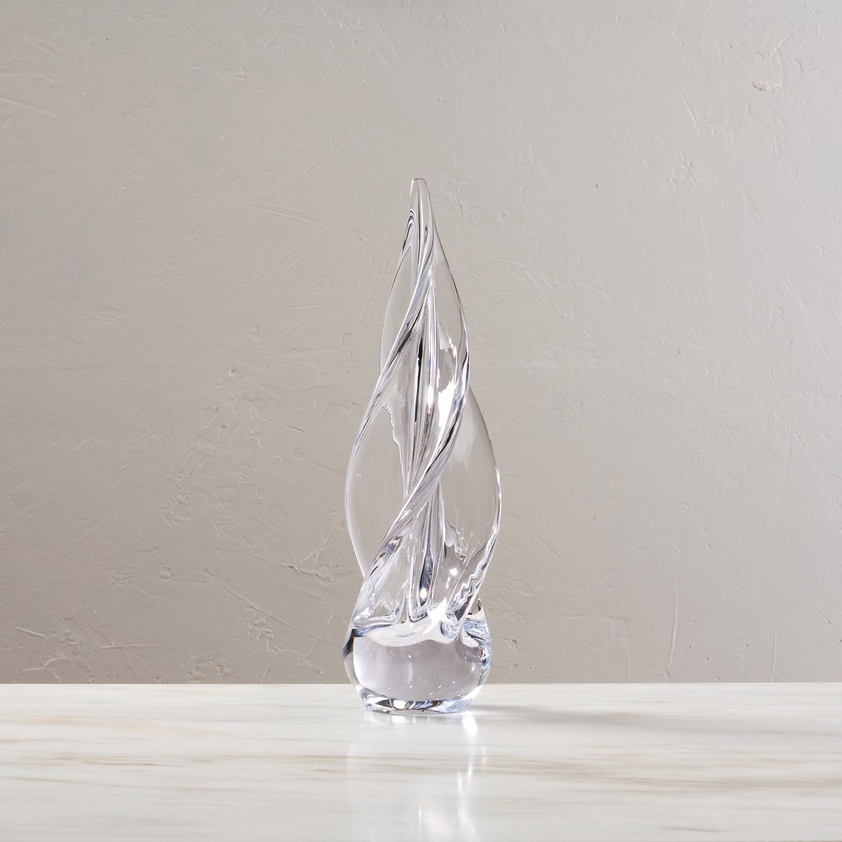 Clear glass spiral tree sculpture with four-sided twisted design and rounded base.