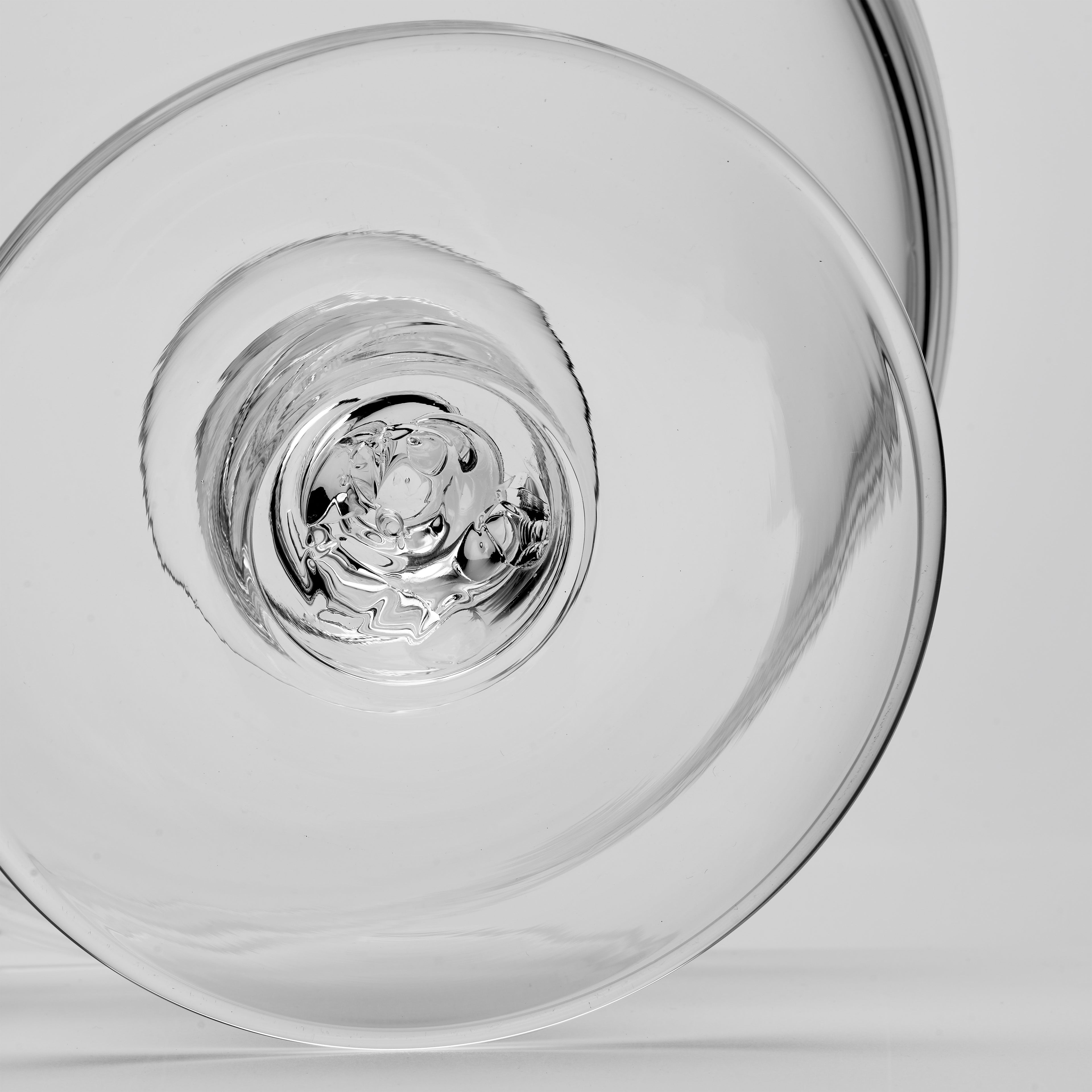 A close-up studio shot of the pontil mark on the round base of a pedestal bowl.